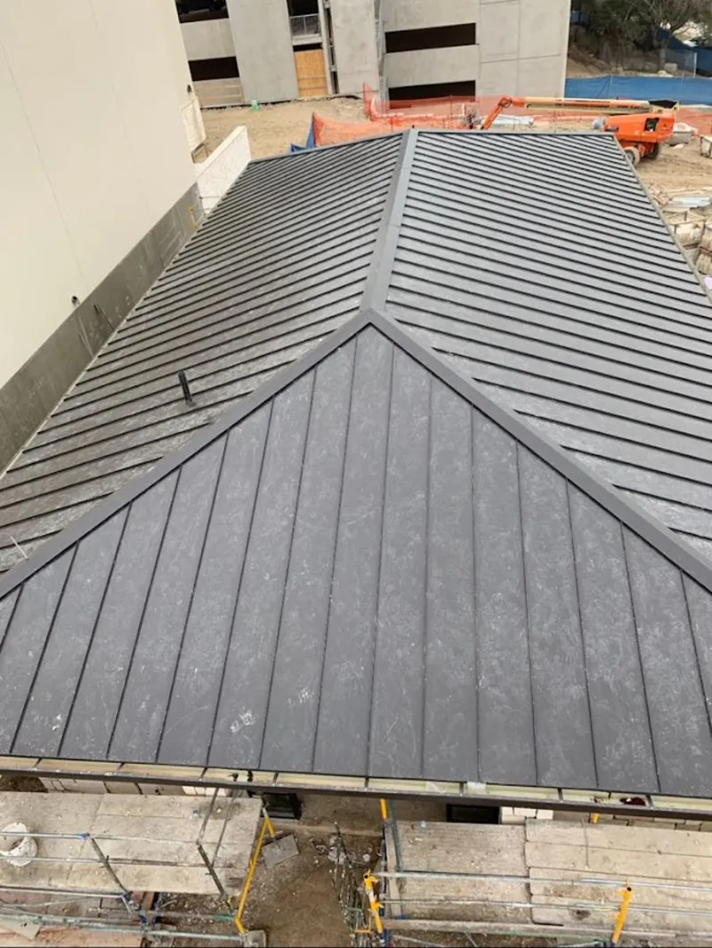 Commercial metal roof construction with crane equipment in Athens